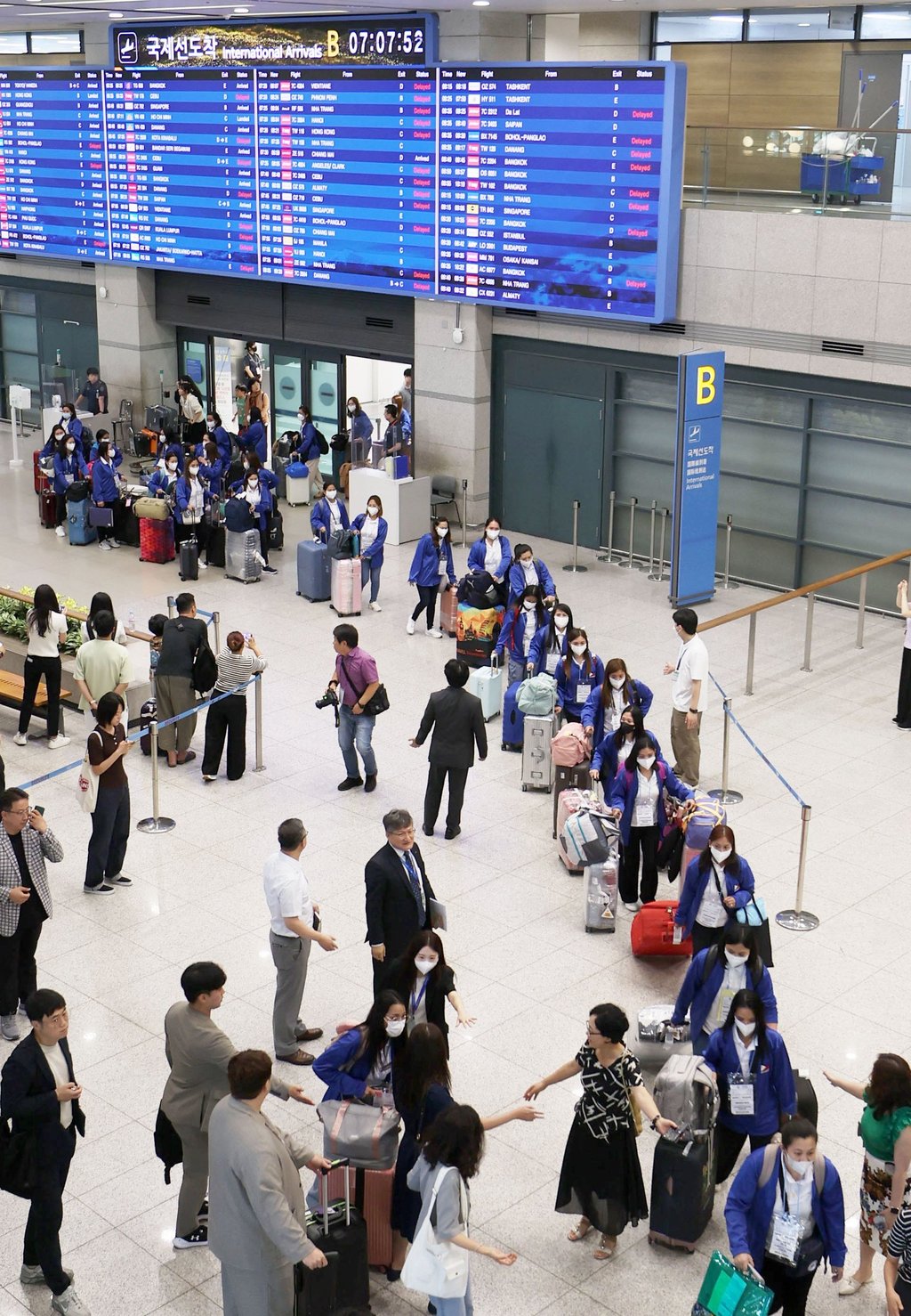 Filipino women (in blue jackets) arrive at Incheon International Airport in Seoul on August 6 to take part in the pilot programme. Photo: Yonhap/EPA-EFE