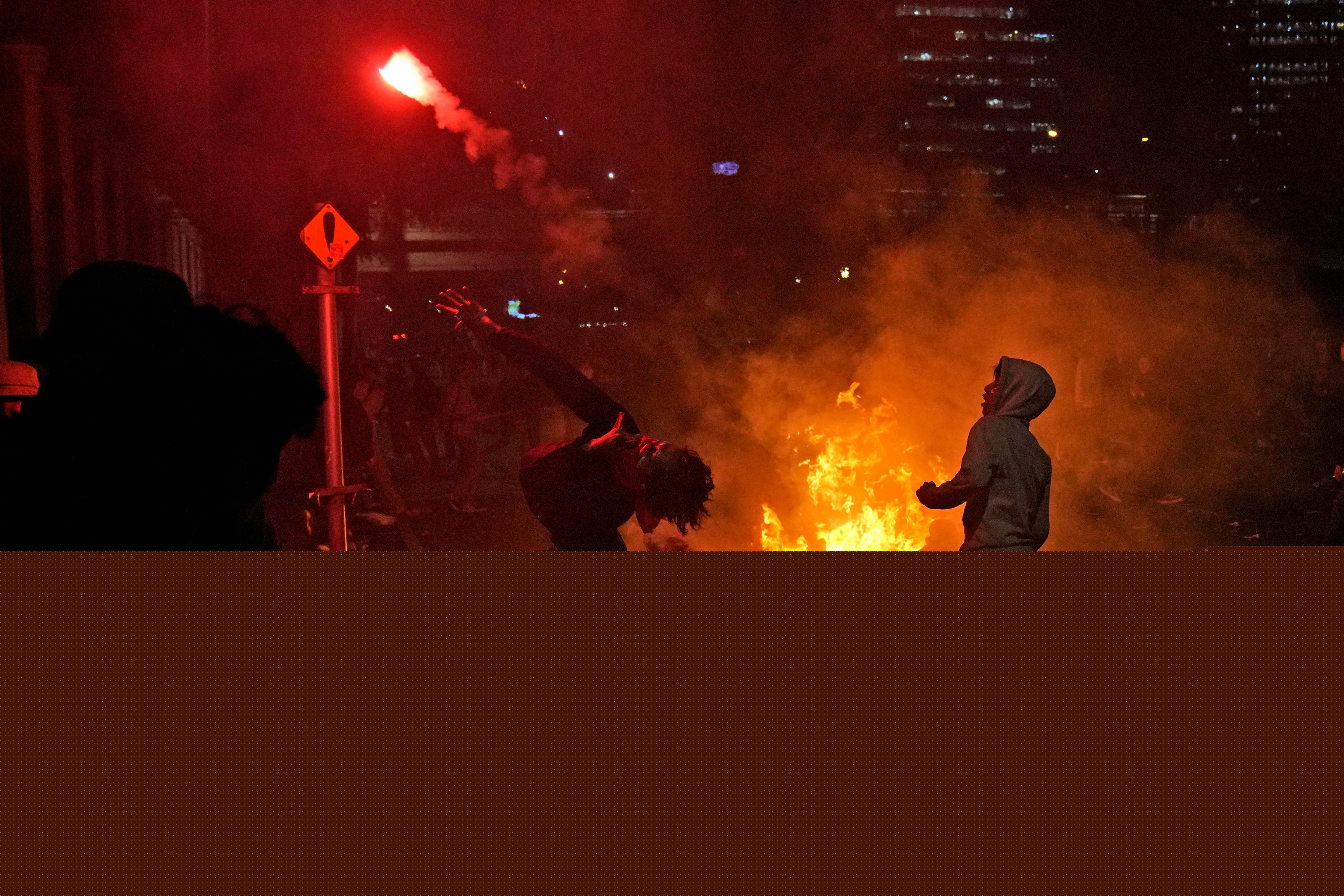 A student protester throws a flare at riot police during a rally on Thursday last week against controversial changes to Indonesia’s election laws. Photo: AP 