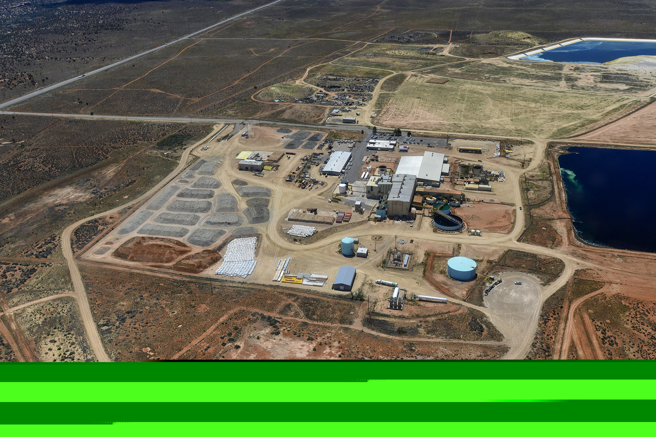 The ore pad at the White Mesa Mill on May 16, 2024. The suspected Japan Atomic Energy Agency containers can be seen at the centre bottom of the photo in a vertical white column beside the bright yellow area. Photo: Tim Peterson / EcoFlight