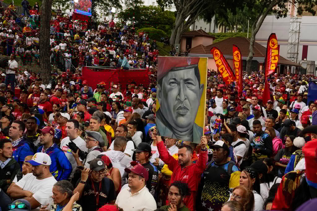 Government loyalists hold a poster of the late former president Hugo Chavez in Caracas. Photo: AP