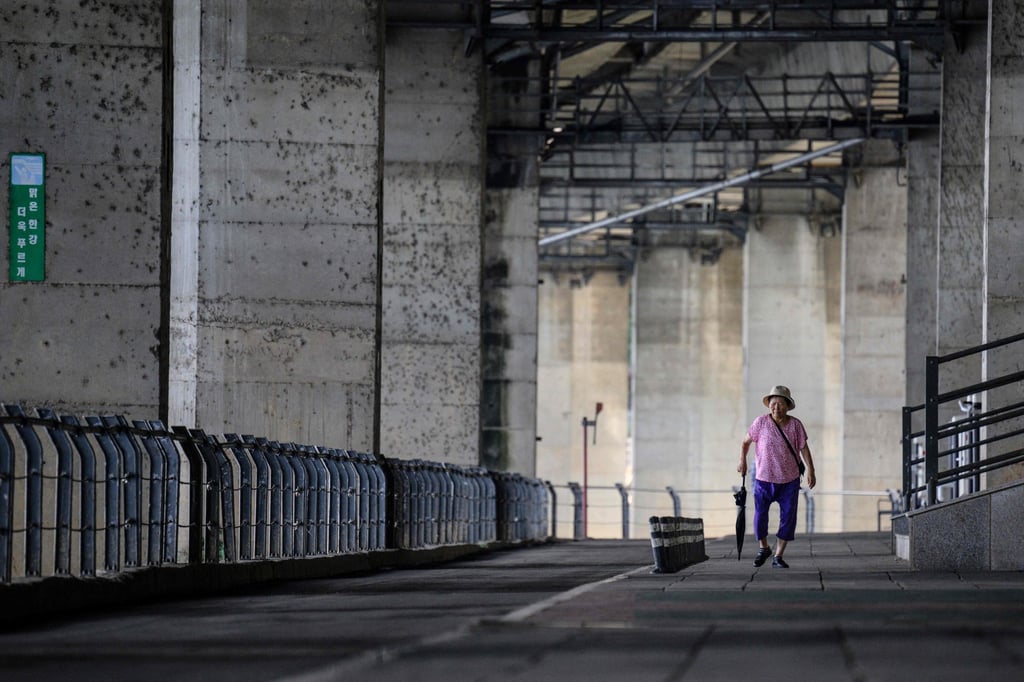 An elderly woman walks along a riverside path in Seoul. South Korea is forecast to have nearly 20 million people aged over 65 by next year. Photo: AFP